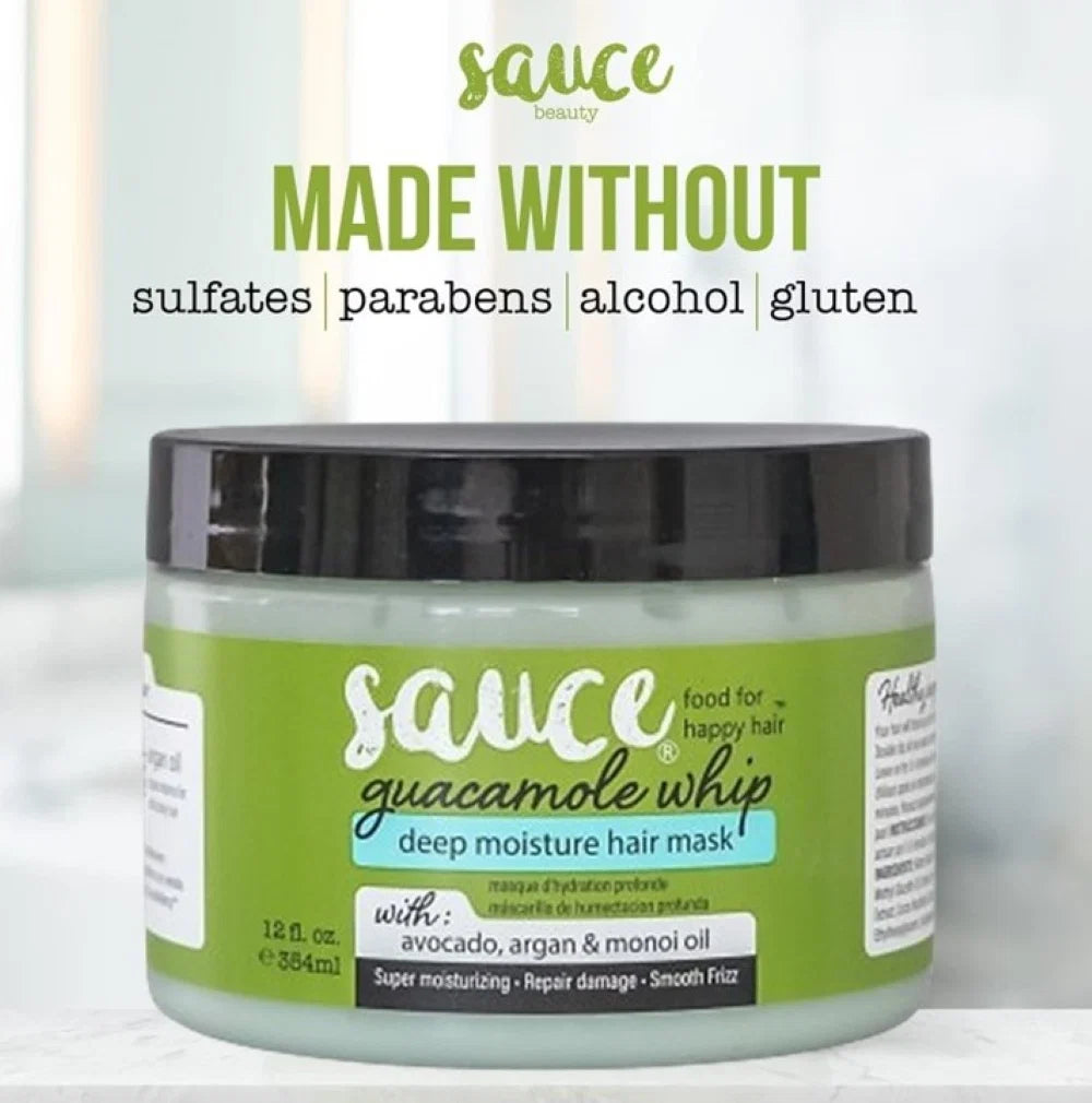 A jar of Sauce Beauty Guacamole Whip Deep Moisture Hair Mask, featuring a light green label and black lid, set against a soft, blurred kitchen background with promotional text overlays.