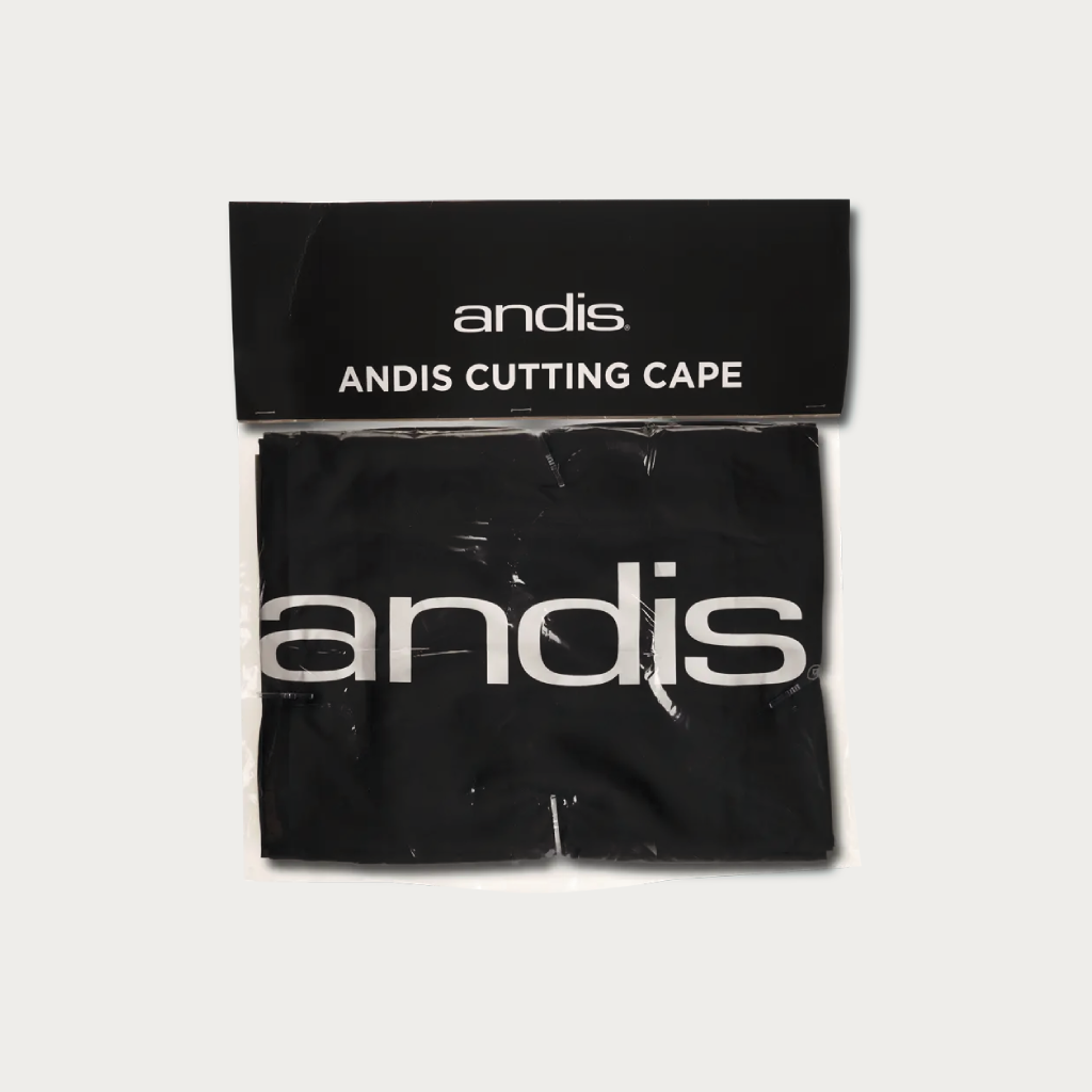 A black Andis cutting cape with a large white 'andis' logo, sealed in a clear plastic bag with a black header card that reads 'andis ANDIS CUTTING CAPE'.